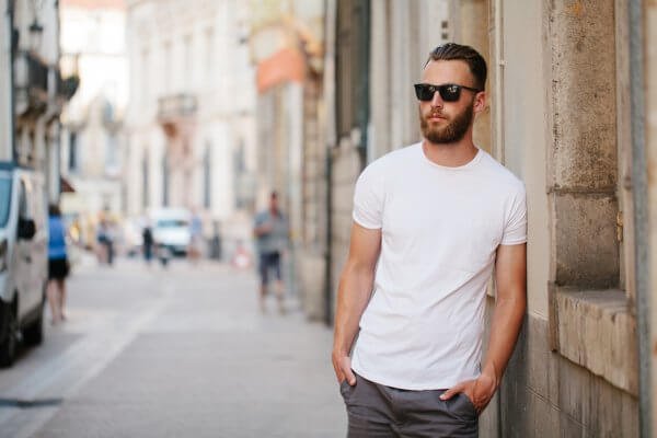homem de camiseta branca e óculos de sol na rua